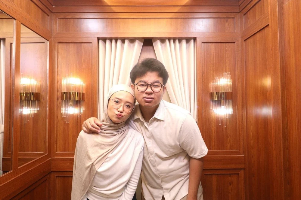 Caca and her partner posing together in white outfits
